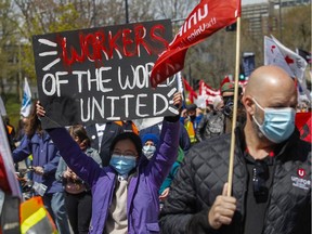 People take part in the May Day march in Montreal on Saturday May 1, 2021.