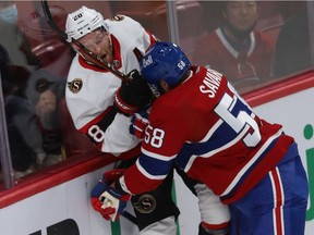 Canadiens' David Savard (58) runs into the boards Ottawa Senators' Connor Brown (28) in Montreal on Oct. 7, 2021.