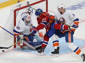 Canadiens' Artturi Lehkonen (62) tries in vain to make a move on New York Islanders goaltender Ilya Sorokin while being grabbed by Scott Mayfield (24) in Montreal on Nov. 4, 2021.
