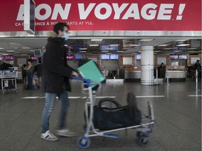 A masked passenger makes his way at the departure level of Montreal Trudeau Airport.