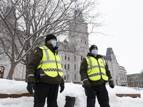 Quebec provincial police officers in front of the legislature, preparing for the arrival of demonstrators against measures taken by authorities to curb the spread of COVID-19, in Quebec City, Thursday, Feb. 3, 2022.
