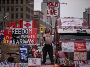 A demonstrator holds a placard during a protest by truck drivers over pandemic health rules and the Trudeau government, outside the parliament of Canada in Ottawa on February 16, 2022.