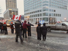 Sûreté du Québec police officers sit in their car blocking the street in the back of the National Assembly, preparing for the arrival of demonstrators against measures taken by authorities to curb the spread of COVID-19.