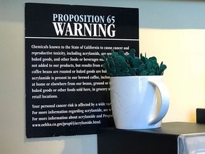 Proposition 65 warning sign is seen behind a coffee mug at a Starbucks coffee shop in Burbank, Calif. in a 2018 photo.