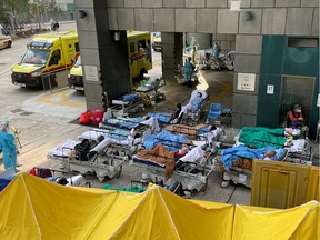 Patients wearing face masks lie in bed at a makeshift treatment area outside a hospital, following the coronavirus disease (COVID-19) outbreak in Hong Kong, China Feb. 16, 2022.