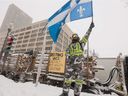 A protester waves a Quebec flag by the National Assembly in Quebec City on Saturday, Feb.19, 2022.  