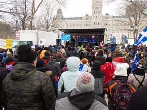 Protest organizers speak to the crowd during a protest near the National Assembly in Quebec city on Feb. 20, 2022.