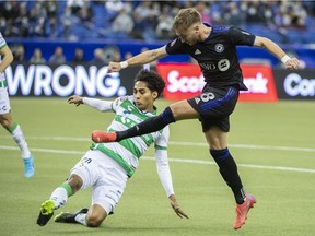 CF Montreal's Djordje Mihailovic (8) shoots and scores as Santos Laguna's Hugo Rodriguez challenges during the first half of the second leg of their 2022 CONCACAF Champions League soccer game in Montreal, Wednesday, February 23, 2022.