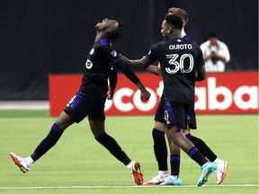 CF Montréal midfielder Ismael Kone, left, celebrates his goal against Santos Laguna with teammates forward Romell Quioto and defender Joel Waterman during the second half at Olympic Stadium on Feb. 23, 2022.