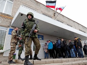 Militants of the self-proclaimed Donetsk People's Republic stand outside a military mobilization point in the separatist-controlled city of Donetsk, Ukraine Feb. 23, 2022.