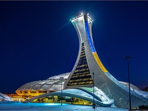 The Olympic Stadium is lit in blue and yellow in Montreal on Sunday, Feb. 27, 2022 in support of Ukraine.