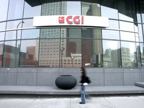 A person walks by a building with a CGI logo on it