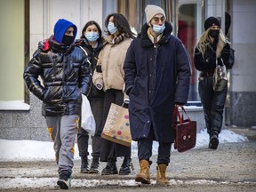 MONTREAL, QUE.: \January\ 28, 2022 -- Masked pedestrians walk on Sainte-Catherine St. in Montreal Friday January 28, 2022. (John Mahoney / MONTREAL GAZETTE) ORG XMIT: 67336 - 2952