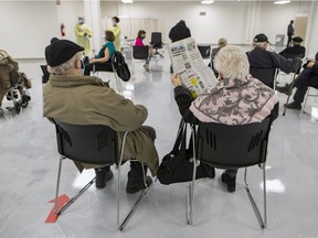 Seniors sit in the waiting area after receiving their COVID-19 vaccinations in Montreal.