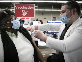 Louis Fequiere Zama receives a first shot of COVID-19 vaccine from nurse Chad Gherbaz in 2021.