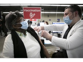 Louis Fequiere Zama receives his first shot of COVID-19 vaccine by nurse Chad Gherbaz at Olympic Stadium in 2021.