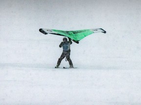 A wing-foil skier glides along frozen Lake of Two Mountains in Vaudreuil-Dorion during a recent blizzard.