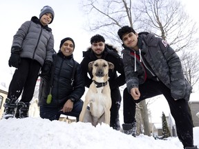 From left, Ethan, father Zach, Dylan and Zain with the family dog, Skye, in Montreal on March 2, 2022.