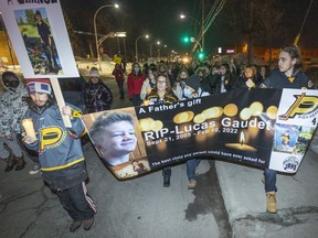 Skyler Robichaud (left) carries a banner during a vigil held for his murdered stepbrother Lucas Gaudet through the streets of Pointe-Claire on March 10.