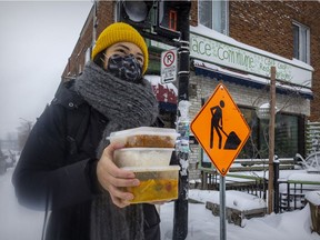 Alison Lee carries her food order from the Parc-Ex Curry Collective, picked up from La Place Commune café. Customers such as Lee have the option to also buy meals for residents experiencing food insecurity.