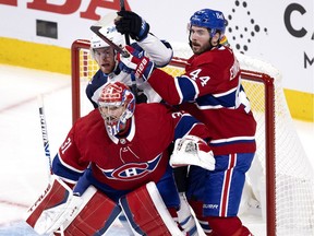 Canadiens defenceman Joel Edmundson checks the Winnipeg Jets’ Andrew Copp while goalie Carey Price follows the puck during Game 3 of second-round NHL playoff series last season.