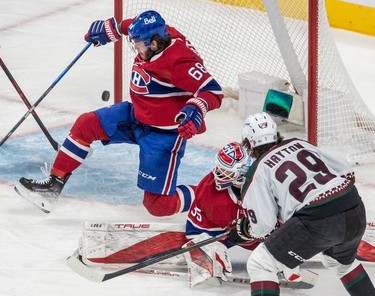 The puck sails past Montreal Canadiens goaltender Sam Montembeault (35) and Montreal Canadiens center Mike Hoffman (68) on a shot from Arizona Coyotes center Barrett Hayton (29) during 1st period NHL action at the Bell Centre in Montreal on Tuesday, March 15, 2022.