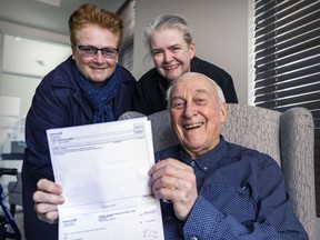 Gilles Labrèche with daughters Chantal and Johanne, left, holds a copy of a cheque from the city of Montreal for the land in Pointe-aux-Trembles that the city took from him in 2017, at the seniors home where he lives in St-Eustache on March 16, 2022.