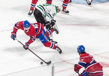 Montreal Canadiens defenseman Corey Schueneman (64) managed to forward the puck to teammate Montreal Canadiens centre Jake Evans (71) after being upended by Dallas Stars centre Tyler Seguin (91) during 1st period NHL action at the Bell Centre in Montreal on Thursday March 17, 2022.