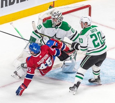 Montreal Canadiens centre Laurent Dauphin (45) is upended by Dallas Stars defenseman Ryan Suter (20) in front of Dallas Stars goaltender Jake Oettinger (29) during 1st period NHL action at the Bell Centre in Montreal on Thursday March 17, 2022.