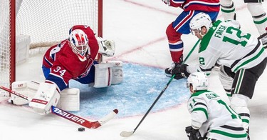 Montreal Canadiens goaltender Jake Allen (34) clears the puck in front of the net with Dallas Stars' Luke Glendening (11) and Radek Faksa (12) closing in during 2nd period NHL action at the Bell Centre in Montreal on Thursday, March 17, 2022.