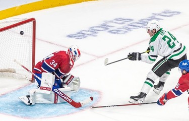 The puck goes wide of the net of Montreal Canadiens goaltender Jake Allen (34) with Dallas Stars centre Roope Hintz (24) in close during 2nd period NHL action at the Bell Centre in Montreal on Thursday, March 17, 2022.
