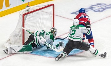 Montreal Canadiens centre Nick Suzuki (14) scored against Dallas Stars goaltender Jake Oettinger (29) with Dallas Stars defenseman Jani Hakanpaa (2) checking from behind during 3rd period NHL action at the Bell Centre in Montreal on Thursday, March 17, 2022.