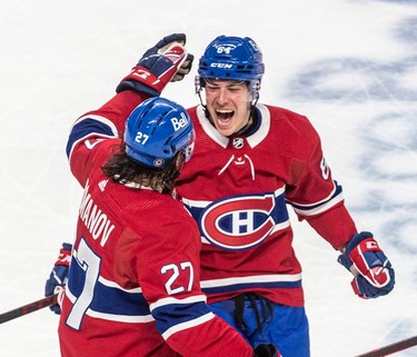Montreal Canadiens defenseman Alexander Romanov (27) congratulates Montreal Canadiens defenseman Corey Schueneman (64) on Schueneman's goal during 3rd period NHL action at the Bell Centre in Montreal on Thursday, March 17, 2022.