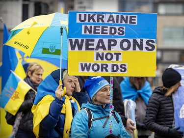Anna Fichman carries a sign during a march through downtown Montreal on Saturday, March 19, 2022, in support of Ukraine and to denounce Russia and Vladimir Putin.