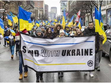 Participants walk down Ste-Catherine St. during a march through downtown Montreal on Saturday, March 19, 2022, in support of Ukraine and to denounce Russia and Vladimir Putin.
