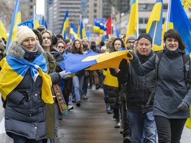 Participants carry a long banner with the colours of the Ukrainian flag during a march through downtown Montreal on Saturday, March 19, 2022, in support of Ukraine and to denounce Russia and Vladimir Putin.