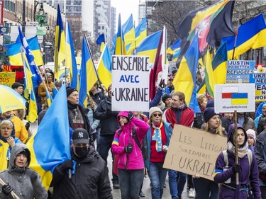 Participants walk down Ste-Catherine St. during a march through downtown Montreal on Saturday, March 19, 2022, in support of Ukraine and to denounce Russia and Vladimir Putin.