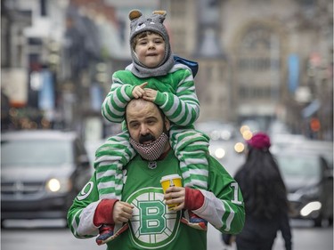 Richard Burnette carries his son, Rowan, on his shoulders following the St. Patrick's parade in Montreal on March 20, 2022.
