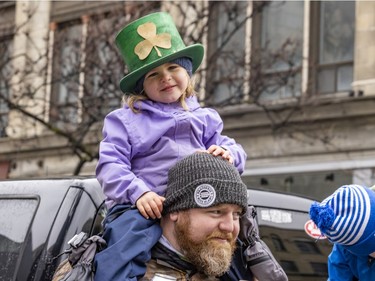 Marc Farley has his daughter, Madden, on his shoulders during the St. Patrick's parade in Montreal on March 20, 2022.