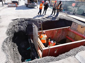Workers examine a sinkhole on Papineau Ave. on March 22, 2022
