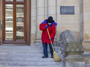A maintenance man sweeps the steps at Dawson College in Montreal March 22, 2022.