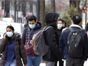 People remain masked on the streets of Montreal on Wednesday, March 23, 2022.