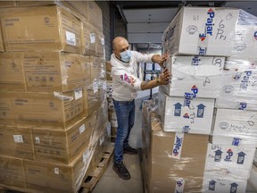 Pajar warehouse manager Alessandro Anthony Paradias wraps up pallets of boots, jackets and medical gowns for shipping to Ukraine at the company's facility in Montreal.