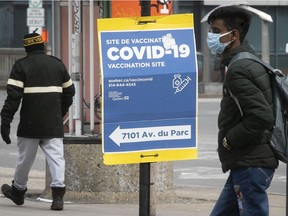 People make their way along Hutchinson St, near a Parc Ave. COVID-19 vaccination clinic on Monday, March 28, 2022.