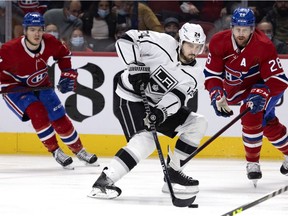 Los Angeles Kings' Phillip Danault moves the puck up the rink as Canadiens' Jake Evans, left, and defenceman Jeff Petry trail in Montreal on Nov. 9, 2021.
