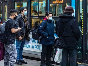 People wearing masks prepared to board a bus in Montreal on Thursday December 16, 2021. The lives of immunocompromised people