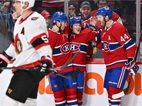 Canadiens' Cole Caufield, centre,  celebrates his goal with teammates Nick Suzuki, left, and Joel Edmundson during the second period against the Ottawa Senators at the Bell Centre on March 19, 2022.