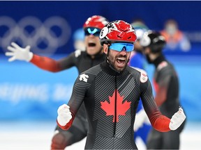 Charles Hamelin celebrates gold medal victory in the 5,000-metre event at the Beijing Olympics on Feb. 16, 2022.