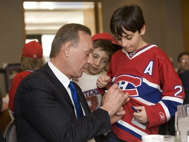 Former Canadiens' star Guy Lafleur signs a young fan's jersey at the Fourth Annual Golden Age of Sports Celebrity Breakfast, a charitable event featuring many stars from different fields of sport, where Lafleur was the guest of honor. Montreal, April 6, 2008.