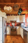 Woven baskets of all shapes and sizes hang from the imposing wooden beam that frames the kitchen’s entrance.